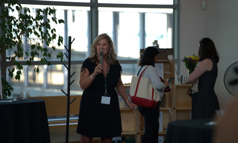 Woman speaking into microphone; Photo Credit: Digital Edge
